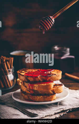 Pila di french toast con sciroppo di berry sulla piastra bianca Foto Stock