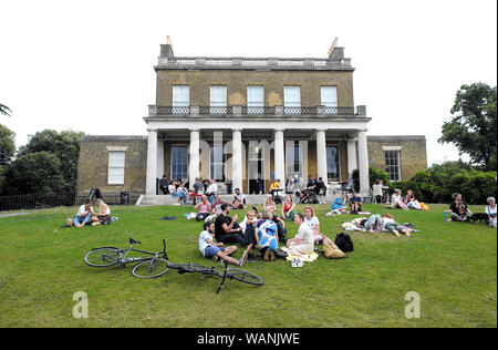 Clissold Park, casa e persone famiglie rilassante al di fuori sul fronte giardino prato con le bici in estate North London N16 Inghilterra UK KATHY DEWITT Foto Stock