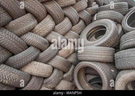 Sfondo, la texture della parete di pneumatici prevista in corrispondenza di un angolo. Nero in gomma di pneumatici, parte del veicolo, parte di ricambio. Foto Stock