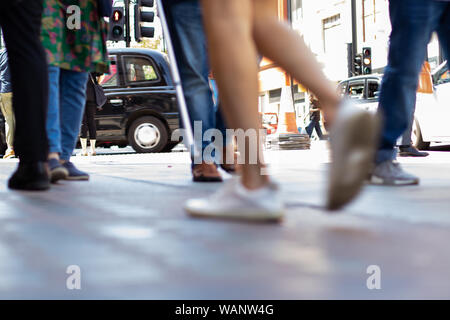 Le gambe delle persone a piedi su Lndon high street Foto Stock