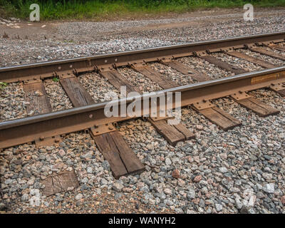 Close-up di una sezione di binari ferroviari, con rotaie e legami (traversine) impostato in pietra la zavorra in funzione di un angolo negli Stati Uniti. Foto Stock