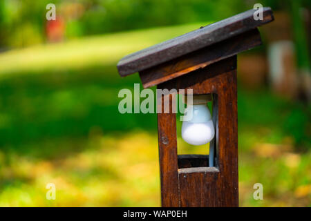 Vintage fuori legno struttura di lampada ma all'interno è la lampada a LED di stabilirsi in giardino. Foto Stock