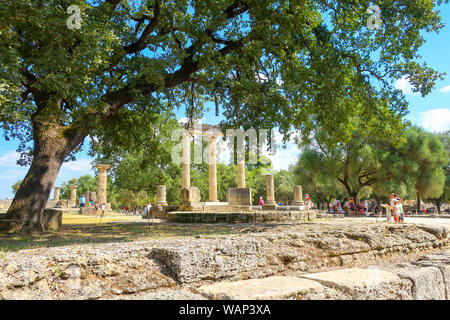 Turisti visitano le antiche Philippeion nell'Altis di Olympia, un tensioattivo ionico memorial circolari in pietra e marmo in Olympia, Grecia. Foto Stock