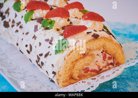 Selfmade fragola rotolare su una superficie di colore turchese Foto Stock