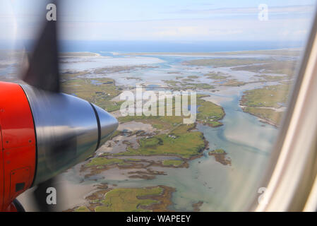 Vista da Loganair twin elica aereo sopra le Ebridi Esterne verso lo sbarco in Benbecula, in Scozia, Regno Unito Foto Stock