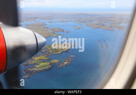 Vista da Loganair twin elica aereo sopra le Ebridi Esterne verso lo sbarco in Benbecula, in Scozia, Regno Unito Foto Stock