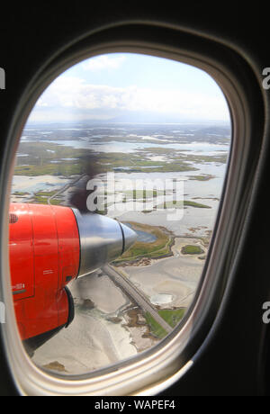 Vista da Loganair twin elica aereo sopra le Ebridi Esterne verso lo sbarco in Benbecula, in Scozia, Regno Unito Foto Stock