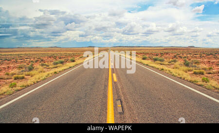 Una strada aperta senza fine attraverso il deserto. Foto Stock