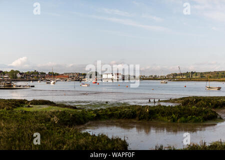 Una vista del Mulino a marea con il fiume Deben in primo piano. Ci sono imbarcazioni a remi e le piccole barche da pesca ormeggiate nel fiume Foto Stock