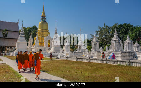 Chiang Mai, Thailandia - Dicembre 21, 2017: gruppo di monaci buddisti a piedi attraverso un tempio bianco con persone in visita Foto Stock