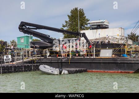 Filmato equipaggio impostazione del gantry e apparecchiature di illuminazione su una chiatta galleggiante Foto Stock