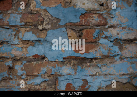 Vecchio muro. un muro di mattoni con peeling vernice blu. Sfondo Foto Stock