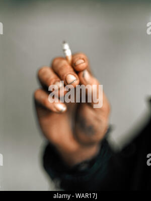 Stretta di mano d'uomo tenendo la sigaretta. Foto Stock