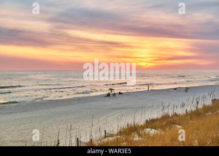 Persone su una Florida Panhandle, Gulf Coast, spiaggia nei pressi di Destin, in Florida, Stati Uniti d'America, al tramonto. Foto Stock