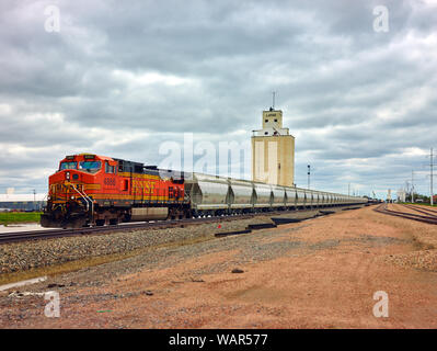 Locomotiva Diesel e ciò che appare come una linea chiusa della tramoggia di vetture su brani di Lamar, Colorado Foto Stock