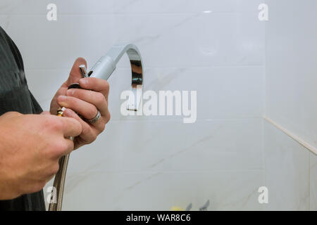 Mani idraulico al lavoro in un bagno installazione un nuovo rubinetto per un lavandino Foto Stock