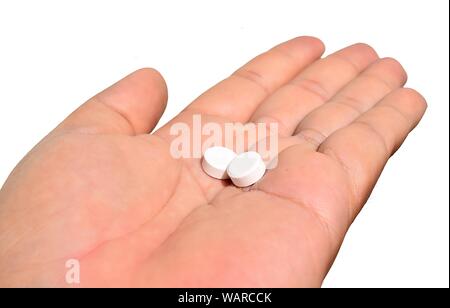 Due pillole di bianco in mano isolati su sfondo bianco,l'uso di paracetamolo,Health care quando malati Foto Stock