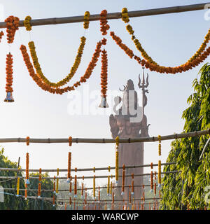 Statua del signore Shiva avvolto in un serpente, tenendo un Trident, al di fuori di New Delhi, India Foto Stock