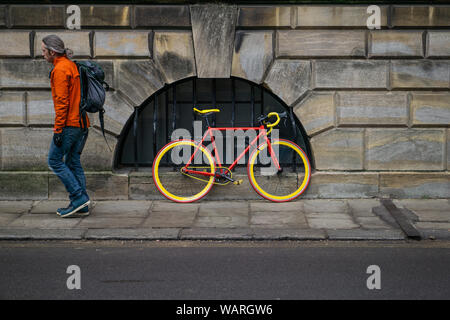 Uomo a piedi lontano dalla bicicletta Foto Stock
