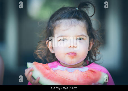 Bambina di mangiare un cocomero in estate Foto Stock