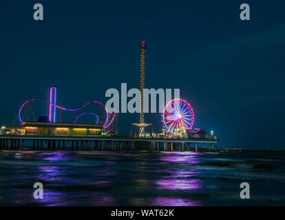 Vista del tramonto, preso dall'adiacente Golfo del Messico a riva, di Galveston Island historic piacere Pier, un'area di divertimenti in Galveston, Texas Foto Stock