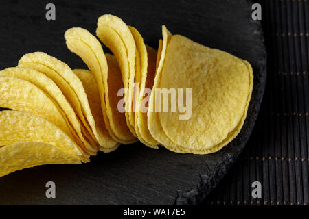 Il salato deliziose patatine su uno sfondo di legno Foto Stock