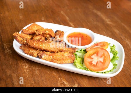 Alette di pollo fritte con salsa di pollo sul piatto. Foto Stock