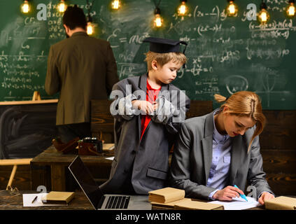 Le attività di formazione in aula a scuola bambino felice è di apprendimento, l'uomo cerca nel display del computer portatile a guardare il corso di formazione e di ascolto, insegnante Foto Stock