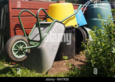 Una ricca collezione di riparto scomparti, benne e contenitori di compost plus una carriola disposti in un heap organizzato Foto Stock