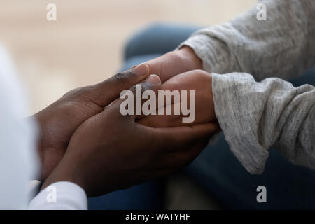 Etnia miste famiglia giovane holding hands esplicito sostegno nel matrimonio Foto Stock