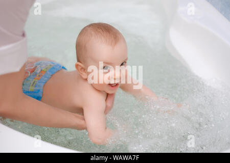 Baby boy ottenendo un massaggio da massaggiatrice. Foto Stock