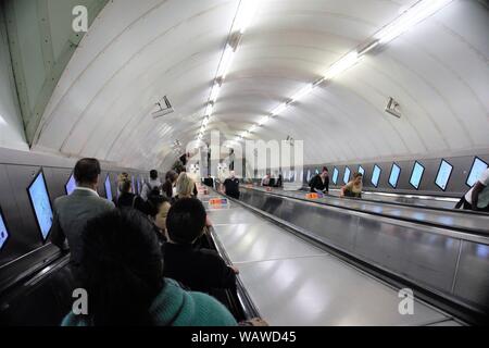 I viaggiatori su scale mobili in alla stazione della metropolitana di Bond Street, Londra, Regno Unito Foto Stock