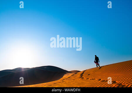 Un uomo è in piedi da solo in Al Wathba deserto. Abu Dhabi. Foto Stock