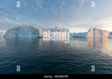 Iceberg di fronte alla cittadina di pescatori Ilulissat in Groenlandia. Natura e paesaggi della Groenlandia. Viaggio su nave tra il CIEM. Il riscaldamento globale Foto Stock