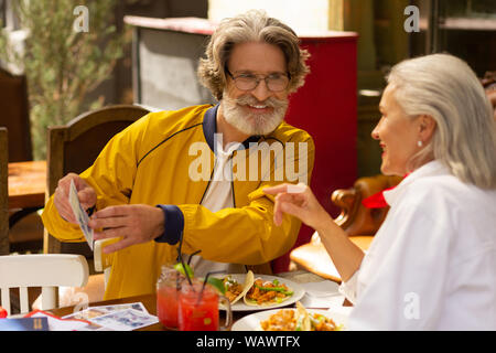 Uomo che mostra la sua moglie la sua immagine preferita. Foto Stock