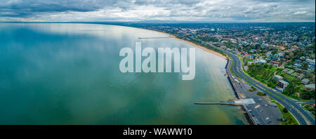 Scenic Penisola di Mornington litorale lungo Frankston sobborgo che mostra due piloni su nuvoloso giorno - aerial paesaggio panoramico Foto Stock