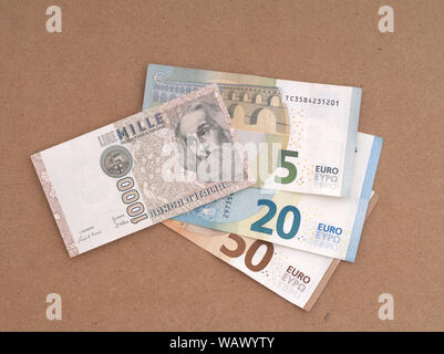MASSA CARRARA, Italia - 14 agosto 2019: Italiano Prodotti vintage e obsoleti di Lire nota le sovrapposizioni e la parte oscura la nuova moneta Euro. Foto Stock