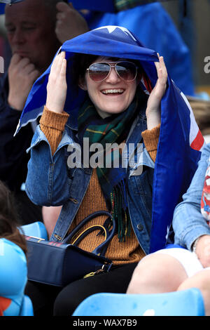 Un Australia rifugi della ventola dalla pioggia sotto una bandiera durante il primo giorno del terzo ceneri Test match a Headingley, Leeds. Foto Stock