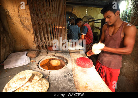 Fornitore del mercato prepara tandoor tradizionale pane nel mercato a Dacca in Bangladesh Foto Stock