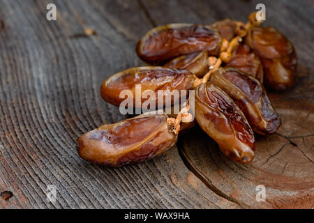 Data la succursale con frutta secca su una vecchia scheda. Close up. Foto Stock