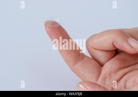 Lente a contatto di close-up su una donna del polpastrello. Buona visione, all'ottico optometrista, trattamento. Foto Stock