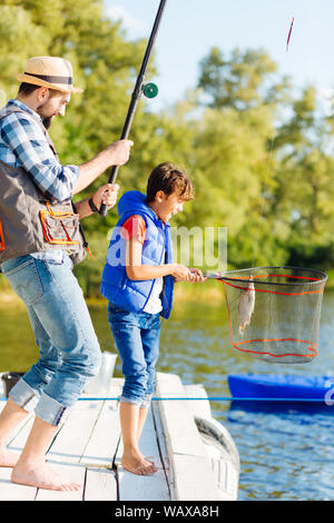 Padre e figlio sentirsi veramente soddisfatti dopo la cattura del pesce Foto Stock