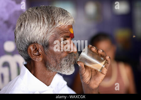 Il tè bevande wallah tè in una piccola stalla tradizionale a Madurai, India. Foto Stock