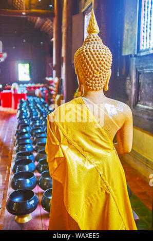 CHIANG MAI, Thailandia - 2 Maggio 2019: il lato posteriore dell'immagine del Buddha di fronte alla donazione bocce in teak scuro viharn (preghiera hall) di Wat Phan Tao tem Foto Stock