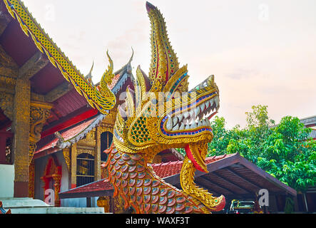La testa del serpente Naga nella parte anteriore del Wat Samphao tempio, è decorato con scale intagliato, dorato e i dettagli colorati, mosaico e specchio luminoso pezzi Foto Stock
