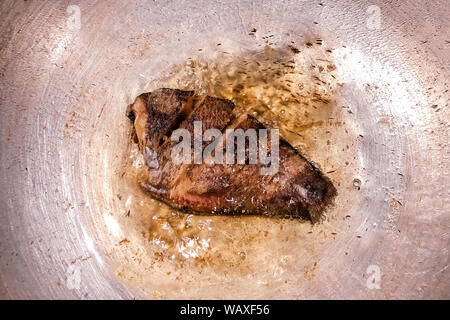 Stile asiatico Tilapia il pesce fritto in padella con olio molto caldo vista superiore Foto Stock