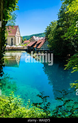 Blaubeuren, Germania, 29 giugno 2019, casa in legno mulino ad acqua e molti turisti soprattutto riflettendo in cristalline acque blu del blu pot (Blau Foto Stock