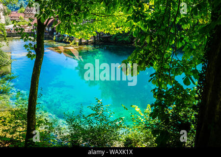 Blaubeuren, Germania, 29 giugno 2019, il paradiso come acqua blu di blu pot (blautopf) fonte naturale nel Giura Svevo con molte persone naturali godendo di m Foto Stock