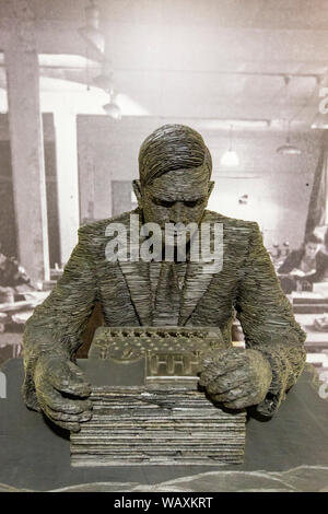 Una scultura di Alan Turing che opera una macchina tedesca Enigma a Bletchley Park, Inghilterra Foto Stock