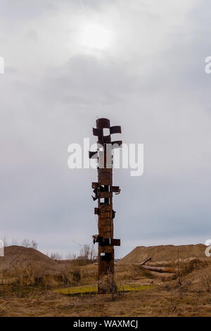 Strano tubo arrugginito bastoni fuori nel mezzo di una terra desolata, somigliante ad un totem pole Foto Stock